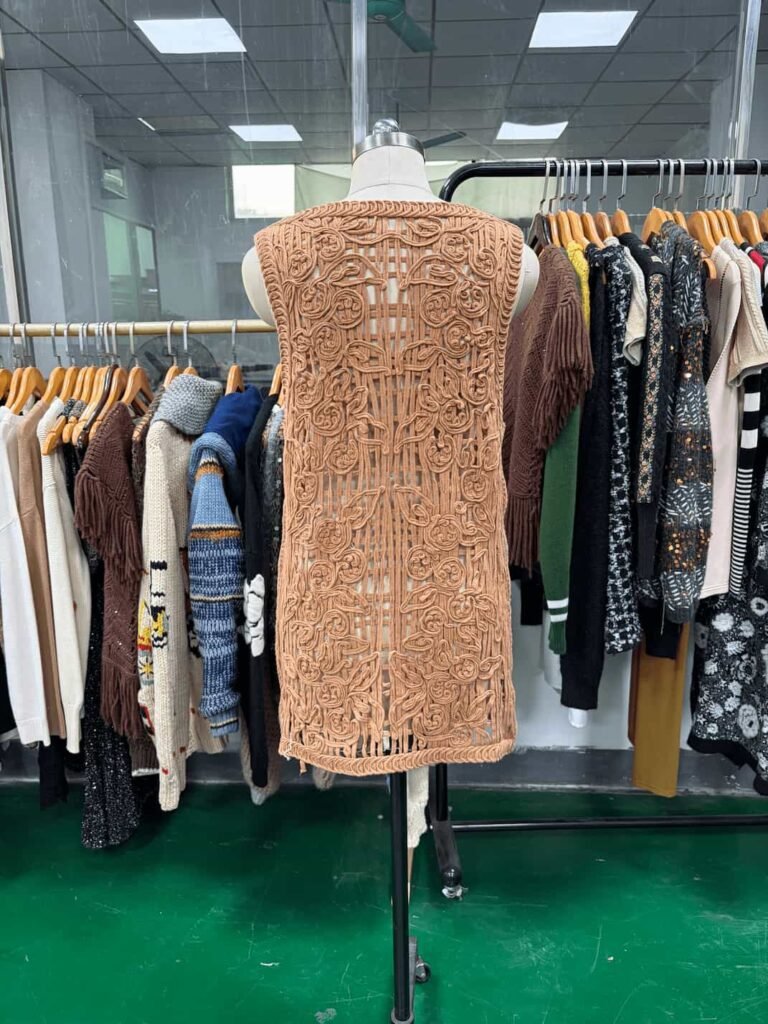 Back view of the beige dress with appliqué and cording embroidery.
