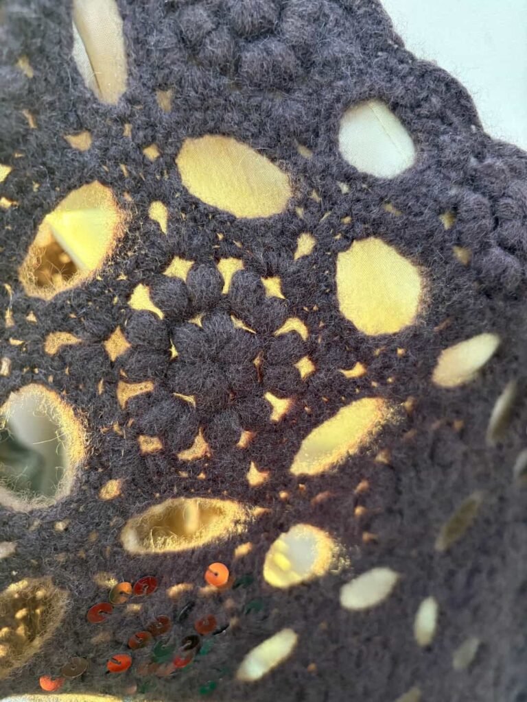 Close-up of sequin-adorned luxury cashmere crochet pattern