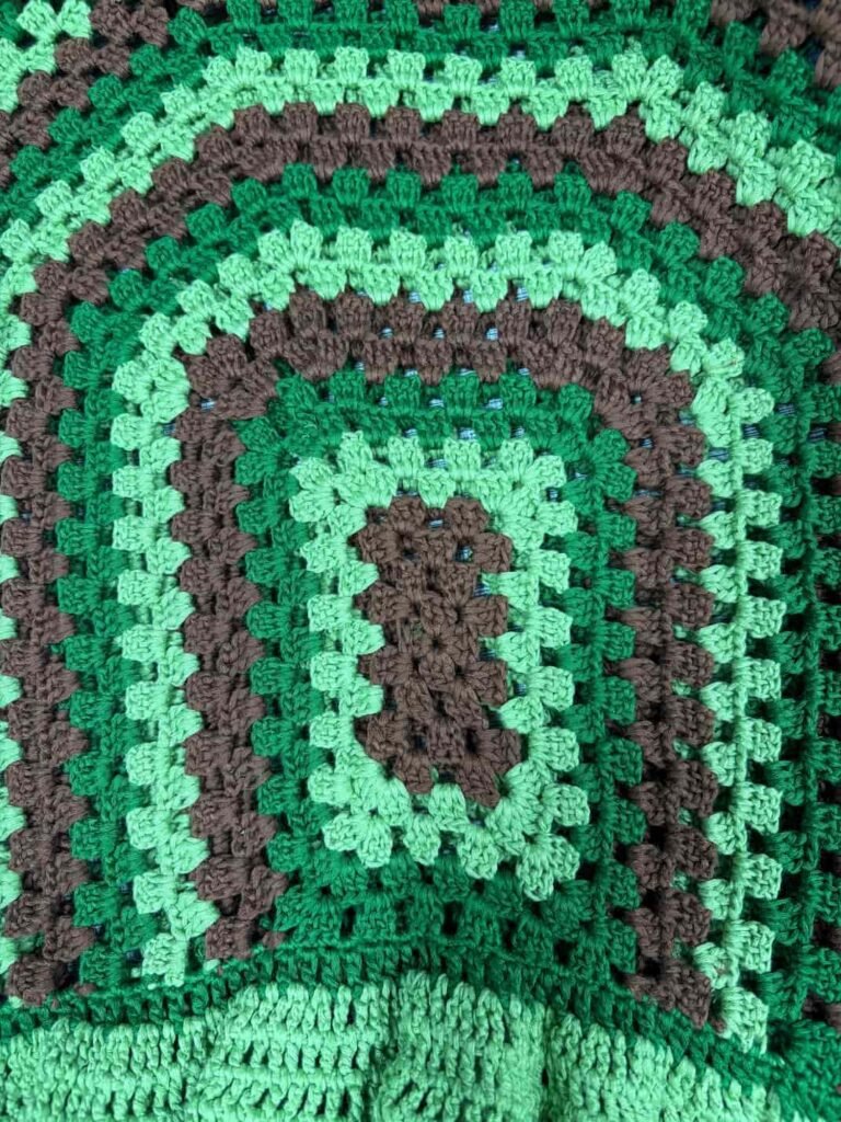 Close-up of green and brown granny square crochet pattern