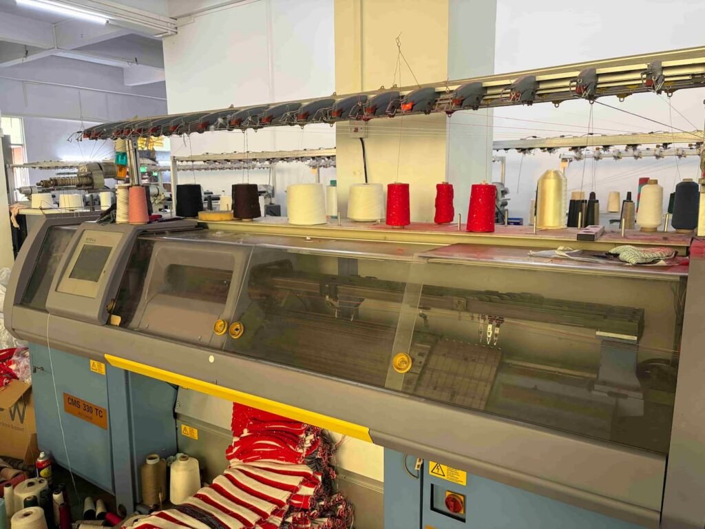 Imported flat knitting machines for premium Artisanal Knitwear Craftsmanship.