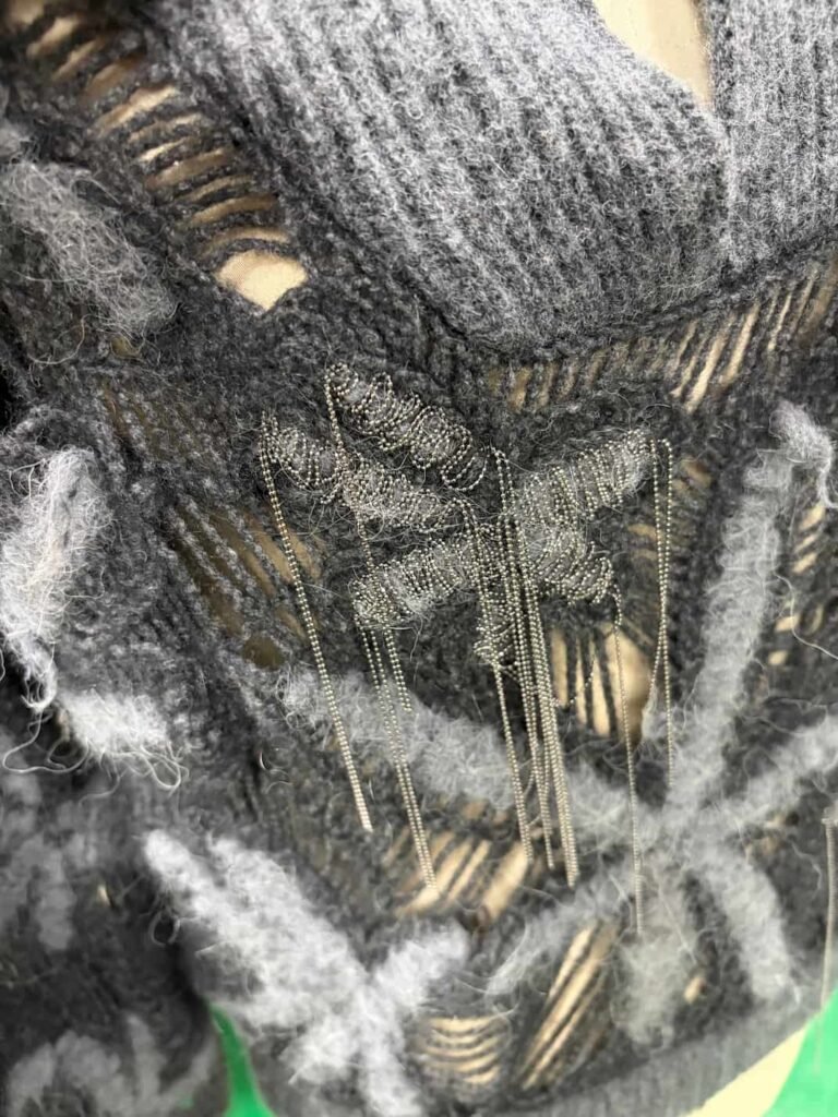 Close-up of metal chain on luxury cashmere knitwear