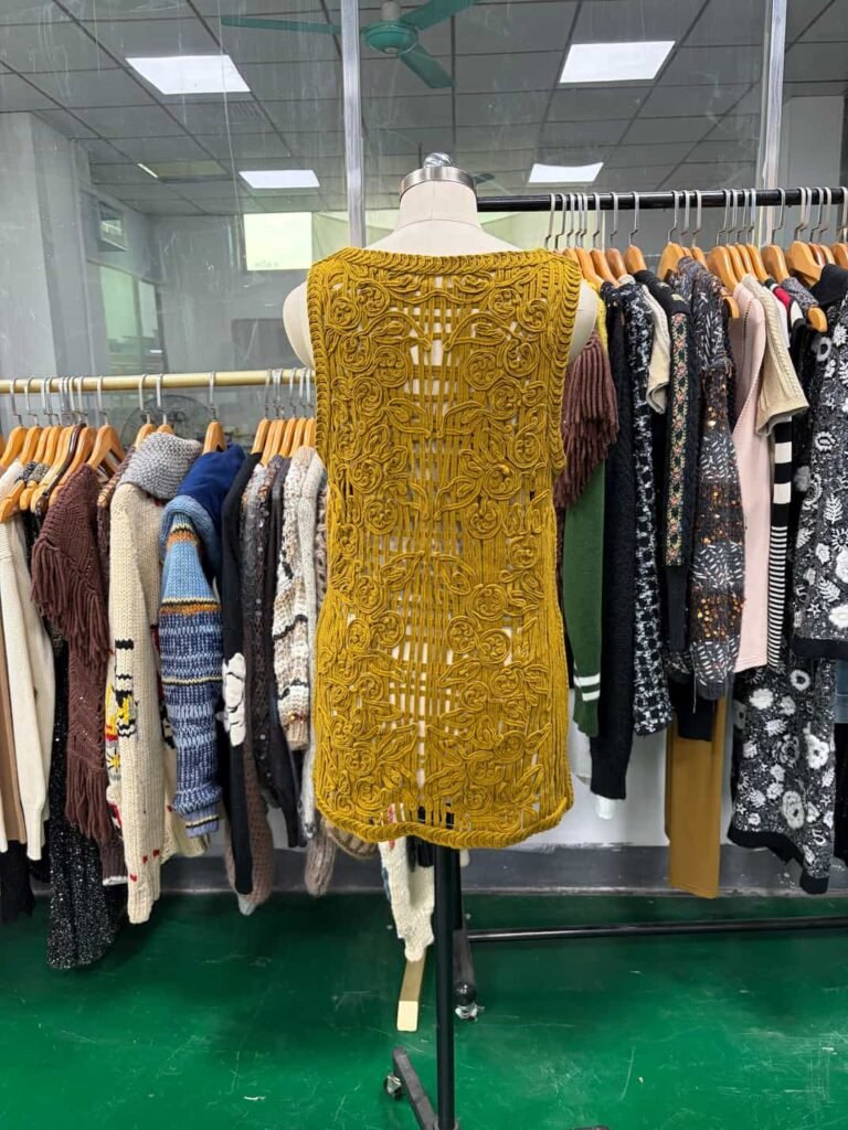 Back view detailing the complex appliqué and cording embroidery of the mustard dress.
