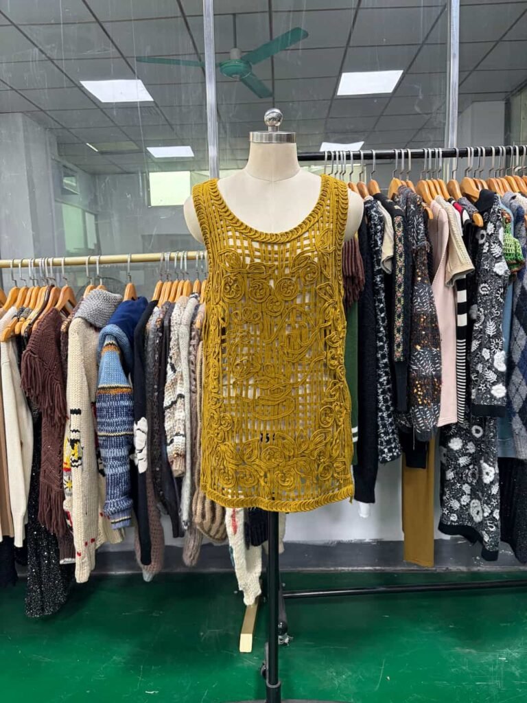 Front view of a mustard yellow dress with appliqué and cording embroidery.