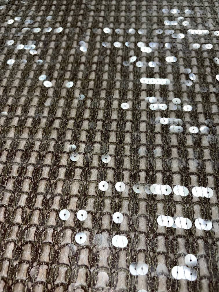 Macro shot of sequin patterns with appliqué and cording embroidery.